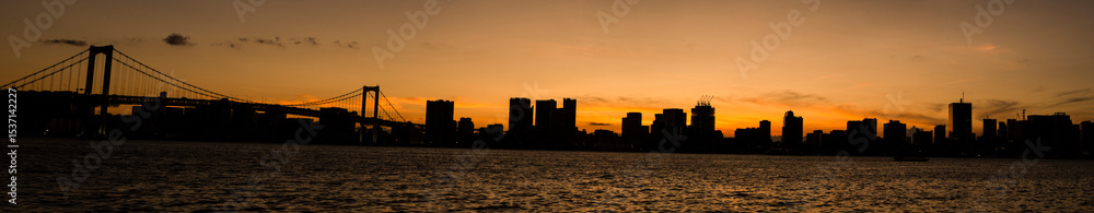 Fototapeta premium 東京豊洲の夕暮れ,オレンジ色に染まる空,マジックアワーを迎える東京湾,オレンジ色の空に染まる豊洲大橋