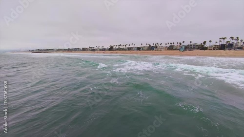 Vista de la costa con olas y cielo gris.