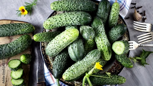 Fresh cucumbers in a bowl on table, top view. Organic fresh harvested vegetables. Vegetables harvest.