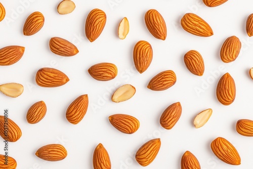 Wallpaper Mural Scattered raw almonds and some halved pieces on a white background, showcasing their natural texture and color. Torontodigital.ca