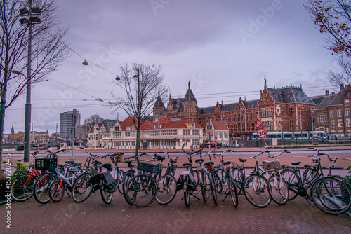 Amsterdam, Netherlands. Many parked bicycles. Along the waterfront, there is beautiful architecture in the Dutch style.