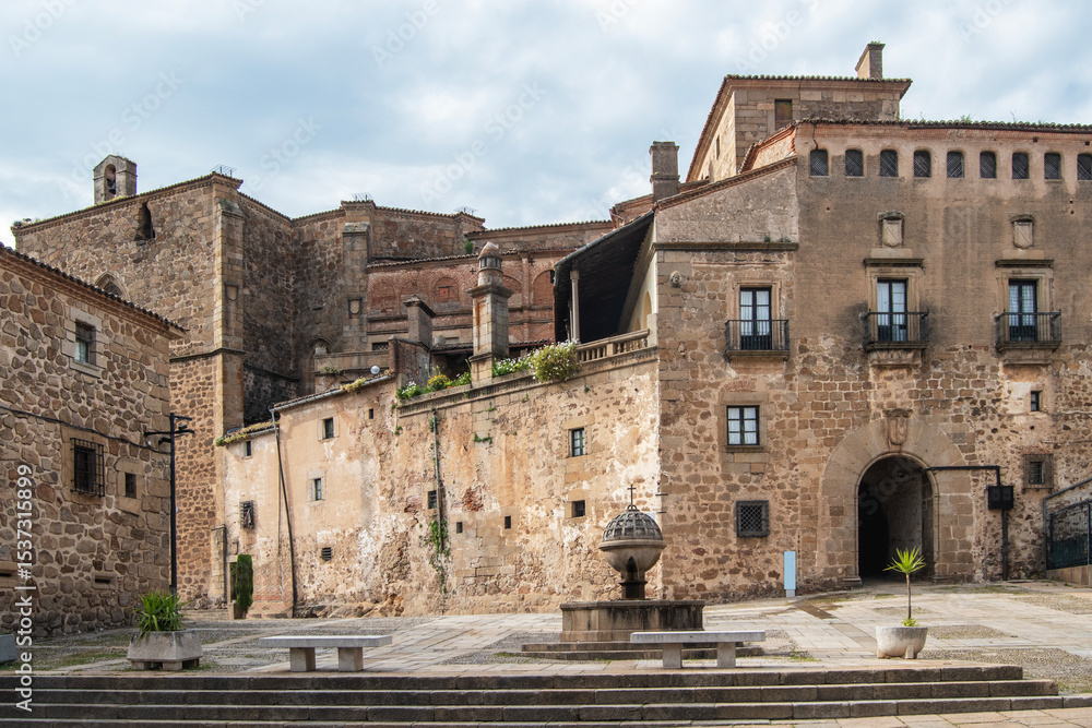 Fototapeta premium Plaza de San Vicente Ferrer with a stone fountain and the palace and passageway of the Marquises of Mirabel in the background, in Plasencia, Cáceres province, Spain