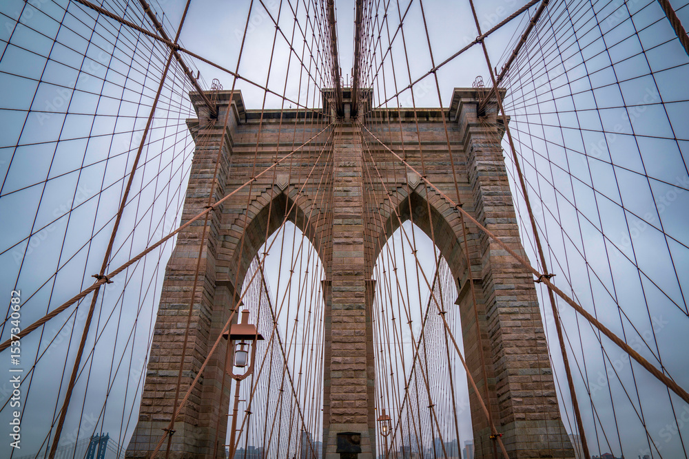 Fototapeta premium Brooklyn Bridge, the cable-stayed suspension bridge opened in 1883 in New York City spanning the East River between the boroughs of Manhattan and Brooklyn, in USA