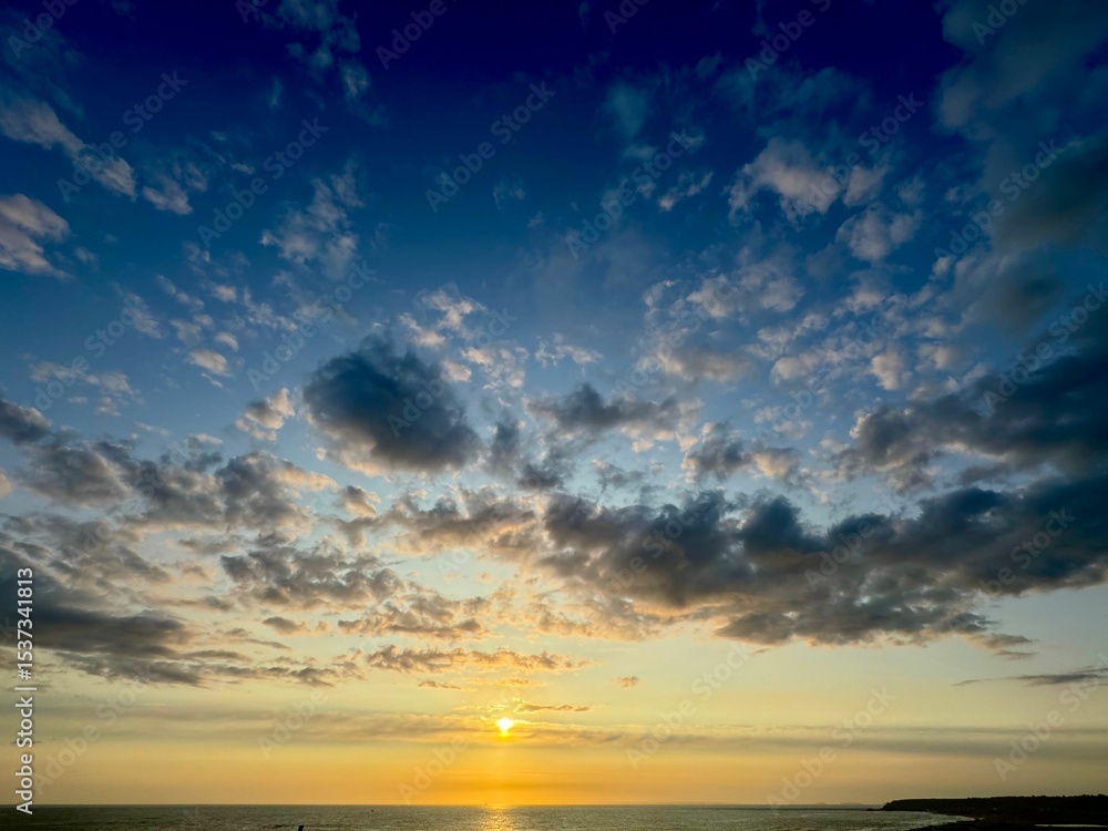 Obraz premium Sunset over ocean with vibrant sky.