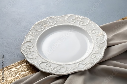 Close-Up of White Scalloped Plate with Ornate Edge on Gray Metallic Surface