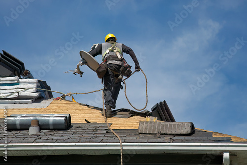 Wallpaper Mural Construction Roofer Wearing Hard Hat Installing Shingles on Residential Roof Against Blue Sky Torontodigital.ca