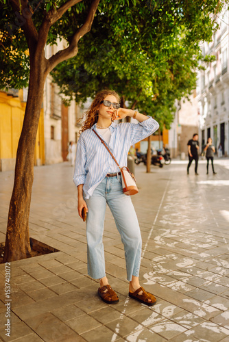 Wallpaper Mural Beautiful tourist strolling along sunny European streets enjoying weather. Cheerful woman looking at architecture. Active lifestyle. Walking concept. Torontodigital.ca