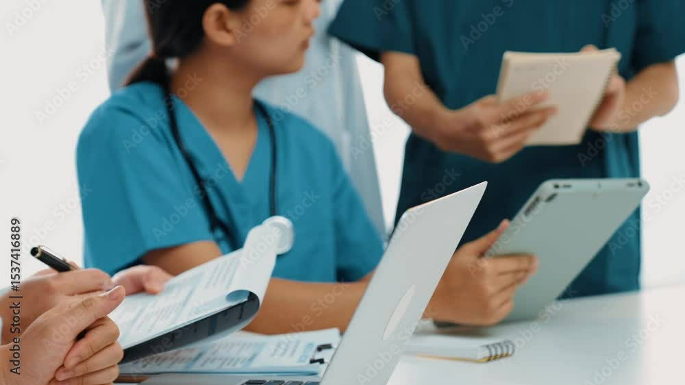 Professional group of medical working and planning medical treatment or healthcare system at hospital table together. Teamwork lead to successful illness and sickness treatment. Slow motion. Rigid. Professional group of medical working and planning medical treatment or healthcare system at hospital table together. Teamwork lead to successful illness and sickness treatment. Slow motion. Rigid.