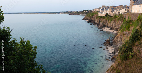 Vista panorámica de los acantilados con piedras cayendo al agua azul del mar en la costa Normanda de Granville en Francia, viajando en verano de 2022