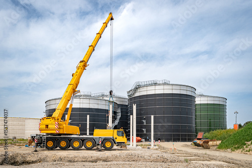 Aufstellen von großen Betonteilen mit einem Baukran für den Bau einer Industriehalle und Biogasanlage.