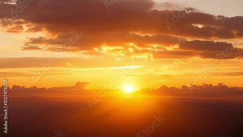 A vibrant sunset over the ocean. The sun is a bright orb peeking through the clouds, radiating light