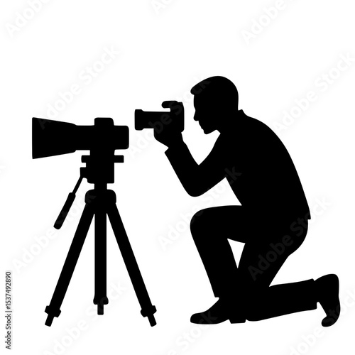 Silhouette of a photographer kneeling while taking a photo on tripods  
