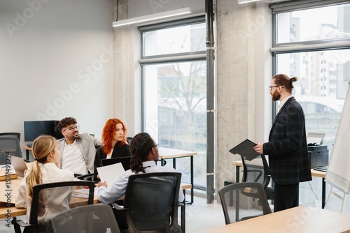 Businessman leading a presentation to his diverse team in modern office
