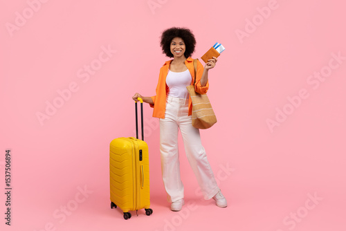Traveling Concept. Portrait Of Happy Black Young Woman With Suitcase And Passport Standing On Pink Studio Background, Cheerful African American Female Ready For Vacation, Full Length, Copy Space