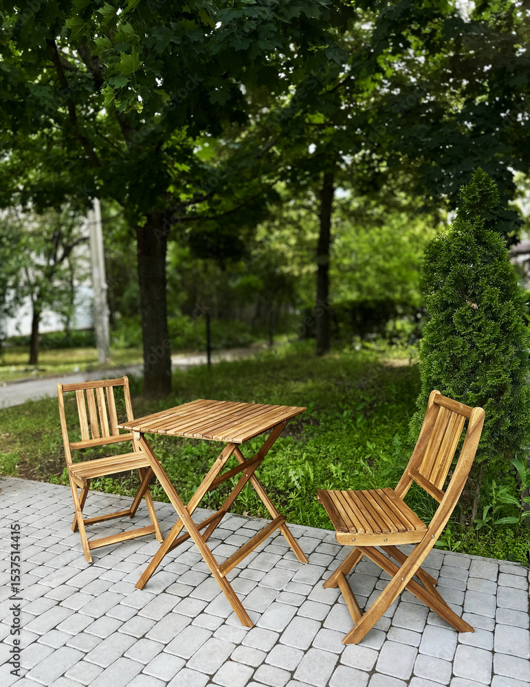 Outdoor wooden table and chairs in green park setting Outdoor wooden table and chairs in green park setting