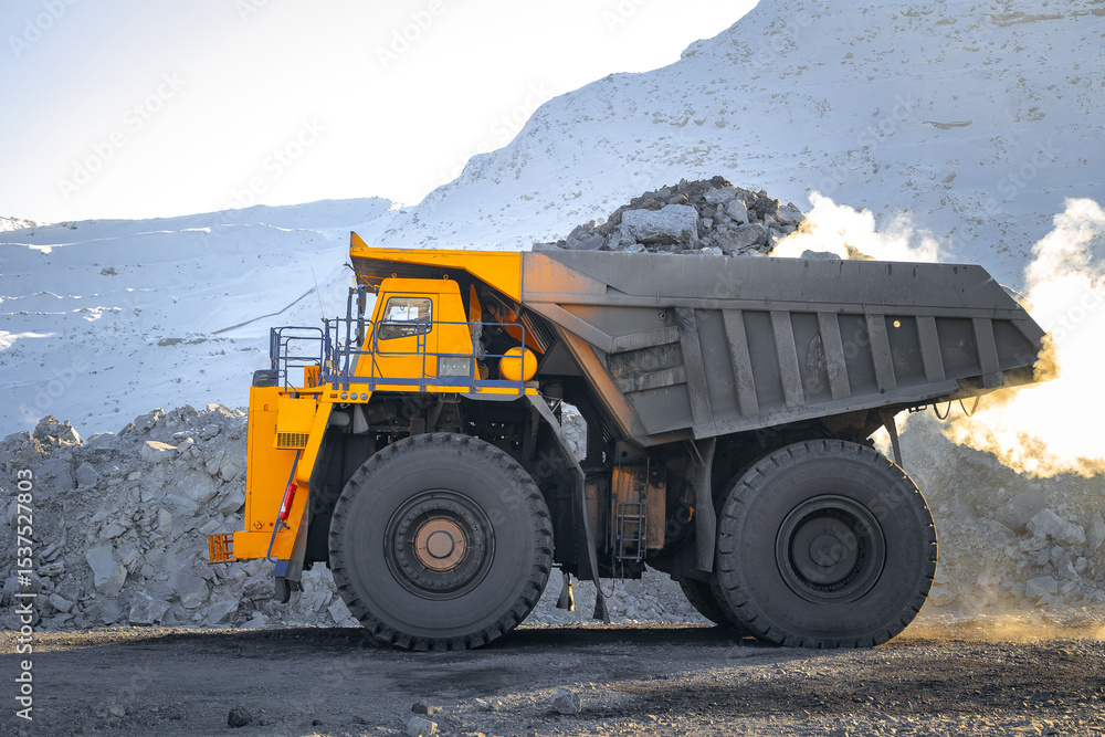 Obraz premium Big yellow dump truck in winter coal mine landscape, banner mining