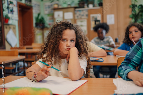 Canvas Print Bored elementary school student during class resting head on hand