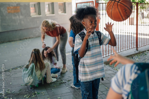 Photography Boy playing basketball with friends after school in schoolyard