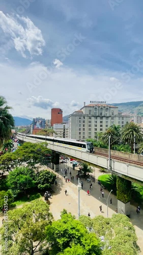 Metro train crossing bridge near historic Nutibara Hotel in Medellin
