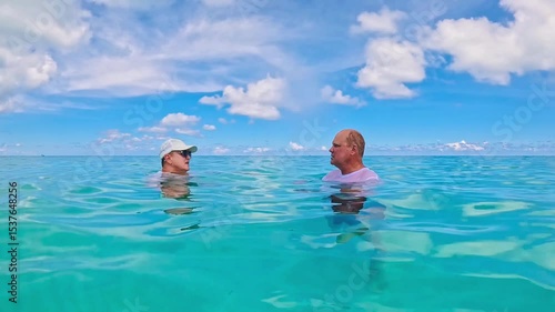 Senior couple talking in the crystal-clear blue water of the Caribbean, Varadero, Cuba