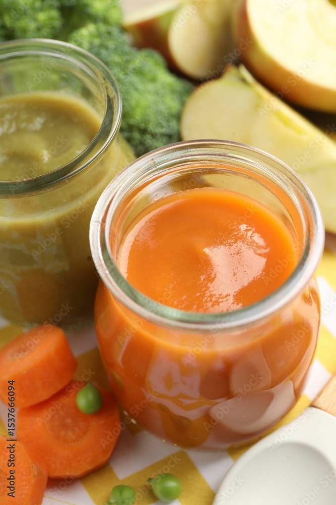 Baby food. Tasty puree in glass jars and ingredients on table, closeup Baby food. Tasty puree in glass jars and ingredients on table, closeup