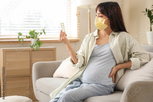 Pregnant Asian woman in yel...