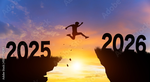 Welcome merry Christmas and Happy new year in 2026. Man jumping across the gap from 2025 to 2026 cliff with Sunset and Twilight Sky background.