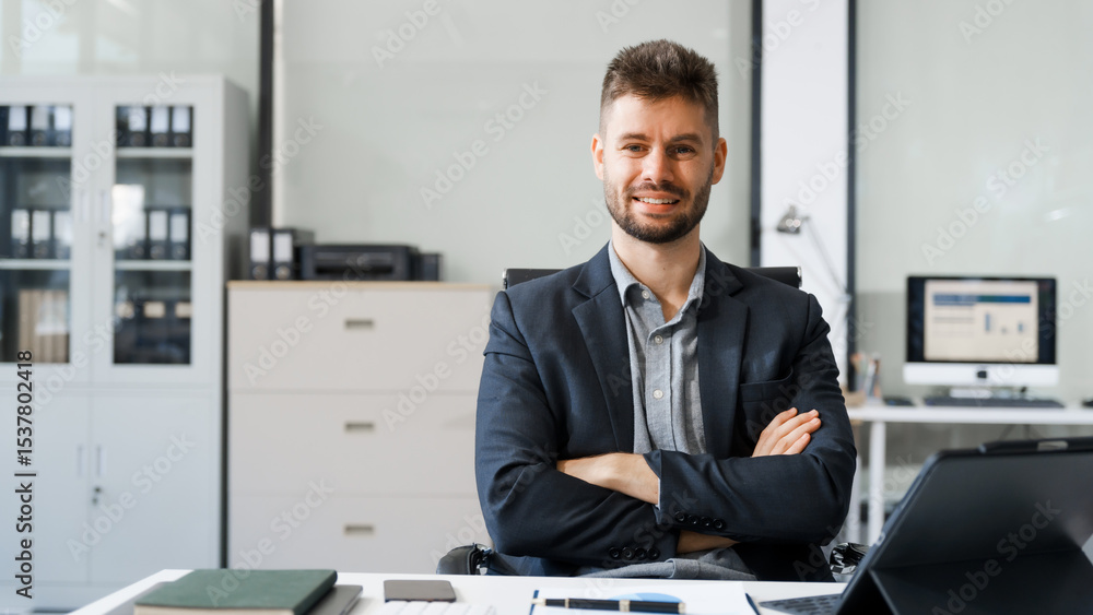 Fototapeta premium A smart Caucasian businessman sits confidently at desk in modern indoor office, using laptop for online consulting, showcasing professionalism, success, digital expertise in corporate environment.