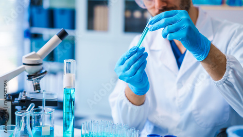 Young Caucasian male scientist works in laboratory, analyzing chemical samples with glassware and microscope. research tools, experiments, data interpretation, pharmaceutical development.