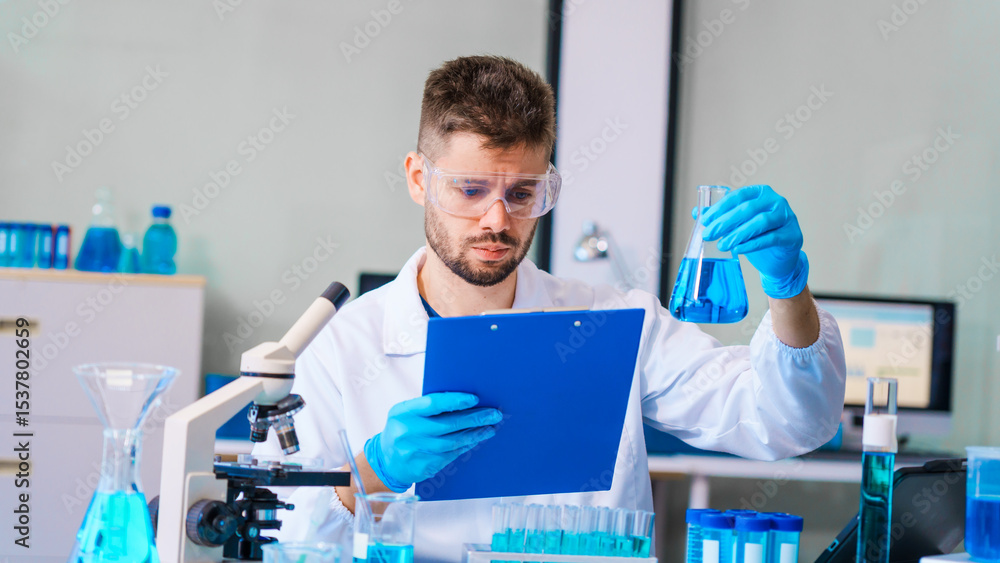 Naklejka premium Young Caucasian male scientist works in laboratory, analyzing chemical samples with glassware and microscope. research tools, experiments, data interpretation, pharmaceutical development.