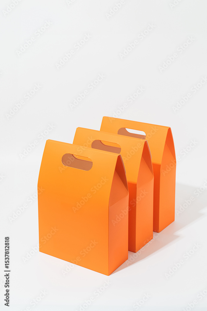 Fototapeta premium Set of three orange gift or shopping bags – clean minimalist packaging mockup