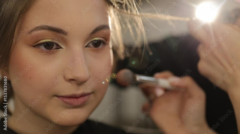 Skilled makeup artist applies blush to model cheeks, highlighting beauty and artistic precision Skilled makeup artist applies blush to model cheeks, highlighting beauty and artistic precision