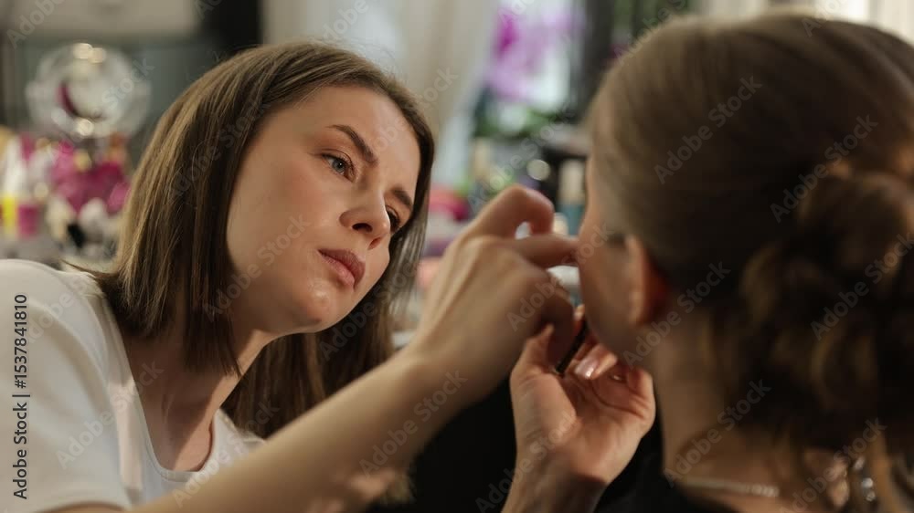 A makeup artist applies exquisite makeup to a bride in an elegant setting, ensuring her radiant look A makeup artist applies exquisite makeup to a bride in an elegant setting, ensuring her radiant look