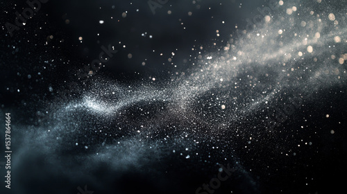 Fine white dust mixed with small stones contrasts against a black background