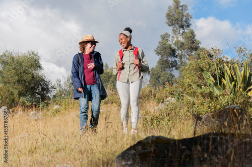 Two female hikers walking and talking in nature preserve