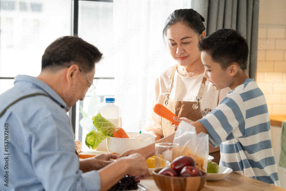 Asian senior couple preparing breakfast with nephew in the kitchen. Happy family spending time on weekend together. Grandparent taking care of grandson. Love and bonding concept Asian senior couple preparing breakfast with nephew in the kitchen. Happy family spending time on weekend together. Grandparent taking care of grandson. Love and bonding concept