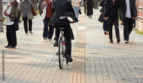 日本の都市の街の通行人と自転車を乗るサラリーマンの姿