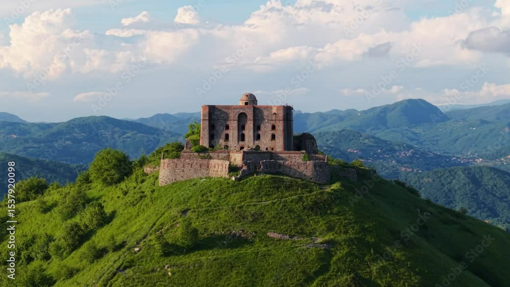 Ancient Italian fort perched atop a hill, surrounded by nature and distant mountains Ancient Italian fort perched atop a hill, surrounded by nature and distant mountains