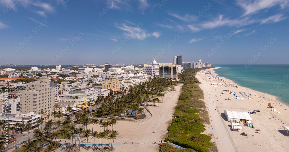 Fototapeta premium Beach in Miami with sunbed on a sandy beach with ocean waves. Miami Beach paradise with stunning views. South Beach Miami lifeguard post. Peaceful seaside retreat in Miami. Coastal relaxation.