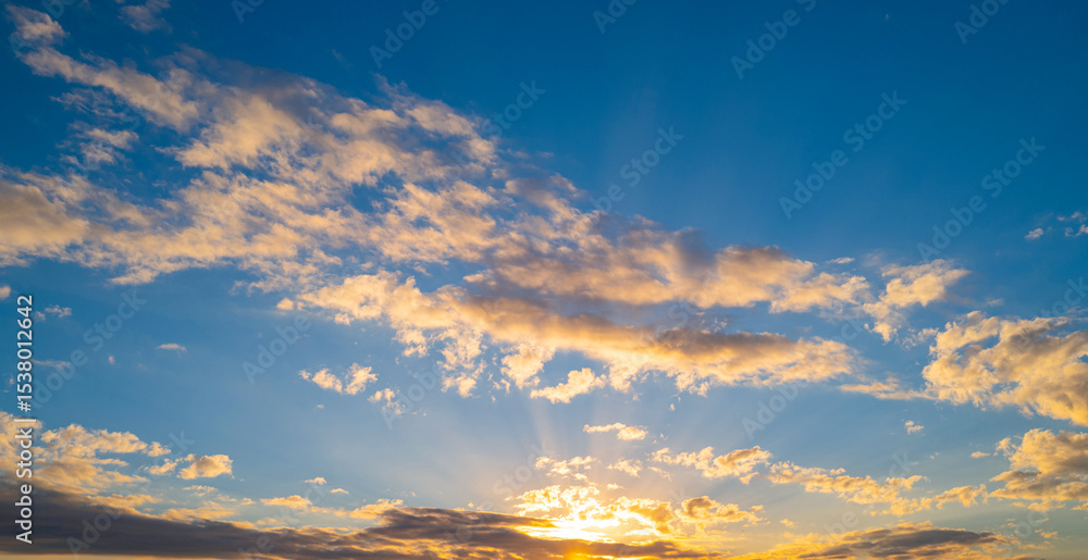 Fototapeta premium Sky at sunset. Sunrise over horizon. Sunlight shining through clouds on sky. Twilight sky with vibrant colors. Peaceful dawn with soft light. Dramatic dusk with glowing clouds. Sunshine in clear sky.