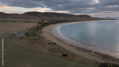 Aerial footage of Kelvedon Beach, Tasmania at sunrise. Captured after a night storm, the video shows moody skies, soft light, and serene coastal beauty in 4K.