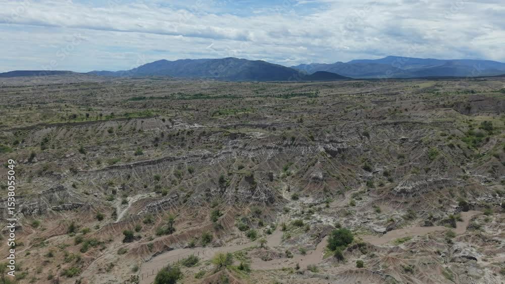 Drone shot of Tatacoa Desert's rugged terrain in Huila, Colombia. Moody skies, vivid earth tones, and vast horizons create a breathtaking panoramic view from above. Drone shot of Tatacoa Desert's rugged terrain in Huila, Colombia. Moody skies, vivid earth tones, and vast horizons create a breathtaking panoramic view from above.