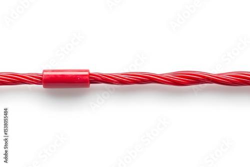 A close up view of a red licorice rope with a red plastic piece on a white background studio shot