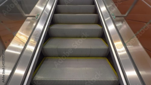 A close-up look at a clean moving escalator with metallic steps and surroundings in a contemporary indoor location.