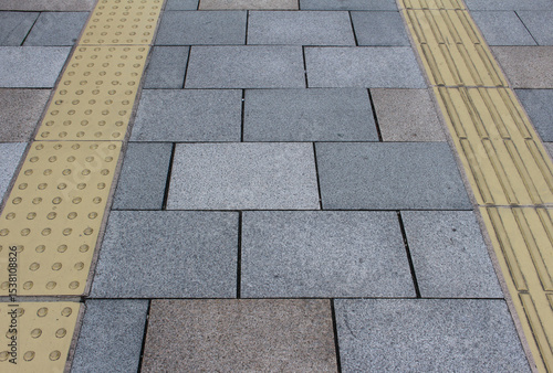 Wallpaper Mural Gray and brown pavement with yellow tactile tiles for blind handicap. Yellow tactile paving on walkway, guiding block for blind and visually impaired. Torontodigital.ca