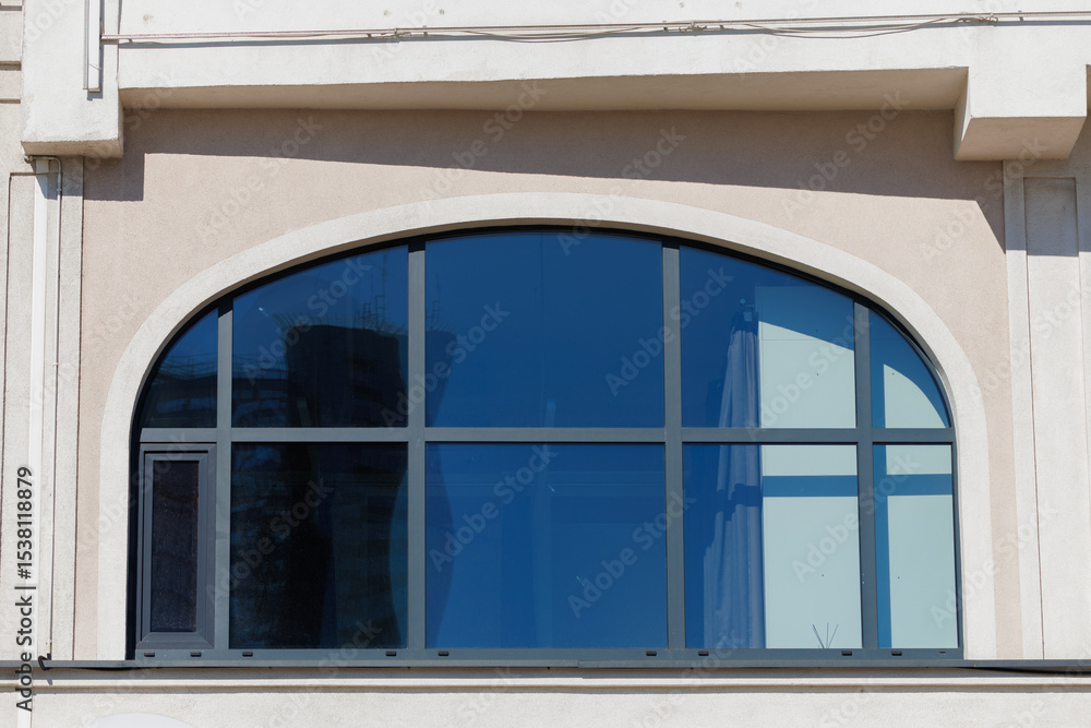 Fototapeta premium City view on a sunny day. Modern building and houses against the blue sky.