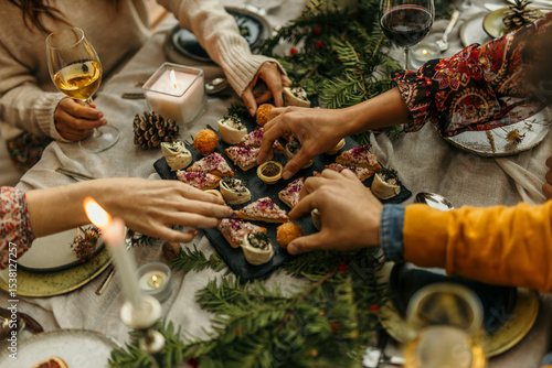 Friends sharing christmas appetizers at festive dinner table