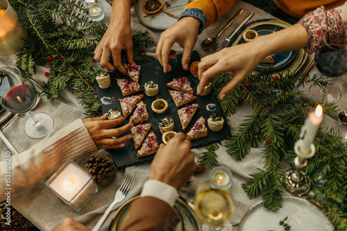Tableau sur toile Friends sharing appetizers at christmas dinner table