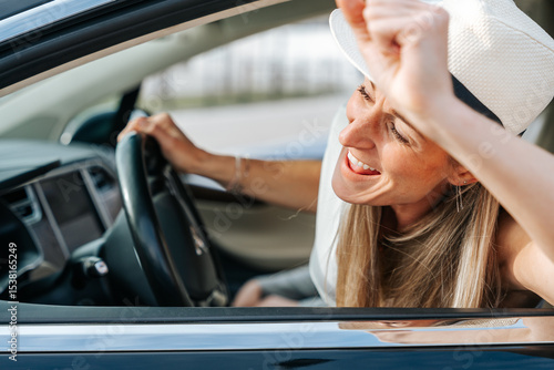 Wallpaper Mural Lady wearing a sun hat leans toward car window admiring the landscape on a quiet summer road journey Torontodigital.ca