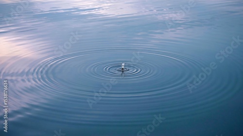 Ripple Effect: Capturing the essence of serenity, a lone droplet creates a symphony of concentric circles, rippling outward across a tranquil expanse of water.